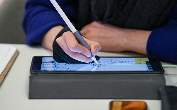 eine Hand mit einem Stift zeichnet auf einem Touchscreen